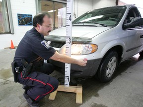 Constable John Walsh measures the impact point on a vehicle at the Police Reporting Centre in London, Ont., in 2006. The centre was celebrating its tenth anniversary; a similar idea is coming to Ottawa. (Susan Bradnam/QMI Agency file photo)