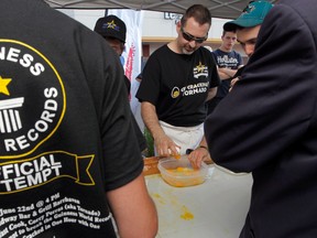 Corey Peras from the Broadway Bar & Grill breaking a Guinness Word Record for cracking eggs with one hand Friday, June 22, 2012. Corey opened 3,031 eggs, shattering the previous record of 2,086. (Tony Caldwell/Ottawa Sun)