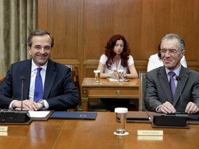Newly appointed Greek Prime Minister Antonis Samaras, left, looks at his next Finance Minister Vassilis Rapanos during a cabinet meeting at the parliament in Athens in this June 21, 2012 file photo. (REUTERS/Yorgos Karahalis/Files)