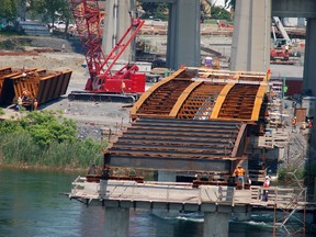 As the girder undergoes a third installation during the low-level bridge construction, the location of a new toll booth is still under debate.