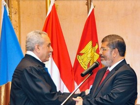 Egypt's new President Mohamed Mursi (R) shakes hand with Farouk Sultan, head of the presidential election commission, after his swearing-in ceremony at the Supreme Constitutional Court in Cairo June 30, 2012. (REUTERS/Egyptian Presidency/Handout)