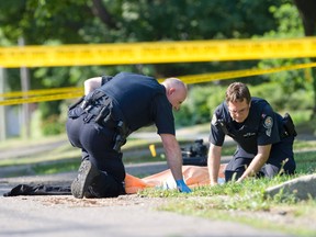 Two Toronto Police officers investigate after a man in his 20s was shot dead on street in an upscale south Etobicoke neighbourhood. (Dave Thomas/Toronto Sun)