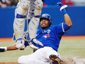 Toronto Blue Jays Edwin Encarnacion is safe sliding into home past Kansas City Royals catcher Salvador Perez (L) during the fifth inning of their MLB American League baseball game in Toronto, July 3, 2012. REUTERS/Mark Blinch