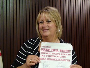 Convenience store owner Joanne McMurchy, of Vanessa, Ont., holds a petition calling for greater choice in buying booze, at Queen's Park Wednesday, July 25, 2012. (ANTONELLA ARTUSO/Toronto Sun)