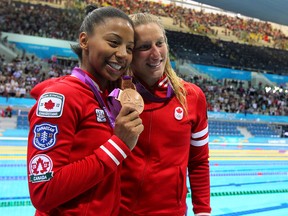 Jennifer Abel (left) and Emilie Heymans celebrate their bronze medal win in 3-metre synchronized diving at the 2012 London Summer Olympic Games in London, England, July 18, 2012. (DAVE ABEL/QMI Agency)