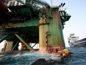 Greenpeace activists climb ladders on the Leiv Eiriksson drilling rig operated by British oil explorer Cairn Energy, 180km  off the Greenland coast, June 4, 2011.  REUTERS/Steve Morgan/Greenpeace/Handout