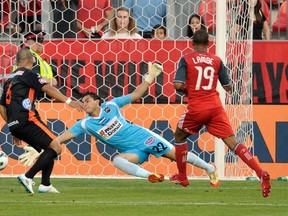 Toronto FC’s Reggie Lambe scores on CD Aguila keeper Benji Villalobos as Mardoqueo Henriquez is too late to help. TFC scored five times on the night. (Mike Cassese/Reuters)