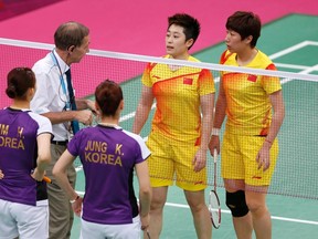 Tournament referee Torsten Berg (2nd L) speaks to players from China and South Korea during their women's doubles group play stage Group A badminton match during the London 2012 Olympic Games at the Wembley Arena July 31, 2012.