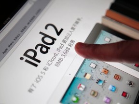 A man touches the screen of an Apple iPad in this March 3, 2012 file photo illustration. (REUTERS/Carlos Barria/Files)