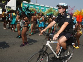 Police line the route at the Caribbean Carnival Grand Parade on Lakeshore Blvd in Toronto on Saturday, August 04, 2012.  (Veronica Henri/ QMI Agency)