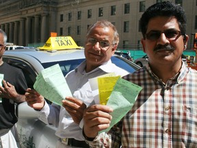 Sajid Mughal,of the iTaxiworkers Association of Ontario (right), displays bylaw infraction tickets along with two of his fellow cab drivers. (TERRY DAVIDSON, Toronto Sun)