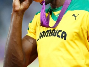 Jamaica's Usain Bolt kisses his gold medal during the presentation ceremony for the men's 200m event at the London 2012 Olympic Games at the Olympic Stadium August 9, 2012. (REUTERS)
