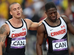 Canada's Jared Connaughton and Canada's Justyn Warner (R) react after the men's 4X100 relay final at the athletics event of the London 2012 Olympic Games on August 11, 2012 in London.  AFP PHOTO / JEWEL SAMAD