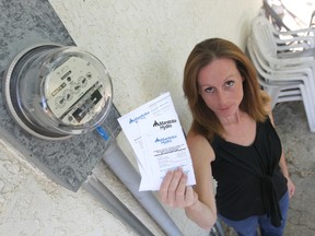 Cindy Flett holds up her Hydro bill. (CHRIS PROCAYLO/Winnipeg Sun)