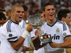 Real Madrid's Pepe (left) and Cristiano Ronaldo celebrate after winning the Spanish Super Cup match against Barcelona at the Santiago Bernabeu stadium in Madrid on Wednesday, Aug. 29, 2012. (Juan Medina/Reuters)