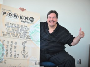 Donald Lawson poses with a copy of his winning numbers in this handout photo release by the Michigan Lottery in Lansing, Michigan August 31, 2012.
