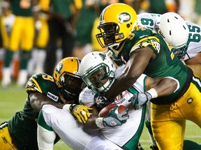 Eskimos defensive tackle Ted Laurent, top, shown here tackling Roughriders’ Kory Sheets earlier this season, has been out for almost a month with an ankle injury, took part in practice this week but doesn't expect to be in the lineup Monday. (Codie McLachlan, Edmonton Sun)
