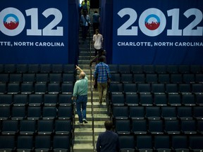 People walk through empty stands in the Time Warner Cable Arena on September 1, 2012 in Charlotte, North Carolina. Preparations for the 2012 Democratic National Convention have begun around Charlotte where the party is expected to nominate US President Barack Obama to run for a second term.  (AFP PHOTO/Brendan SMIALOWSKI)
