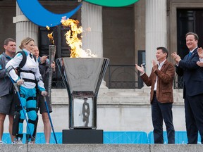 Chairman of LOCOG Lord Sebastian Coe, (3rd R) British Prime Minister David Cameron (2nd R) and London Mayor Boris Johnson (R) applaud as British paralympic athlete Claire Lomas (2nd L) lights the Paralympic Cauldron in London's Trafalgar Square on August 24, 2012. The London 2012 Paralympic Games begin on August 29, 2012. AFP PHOTO / WILL OLIVER