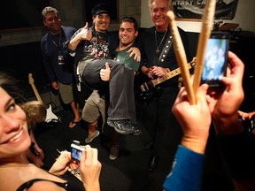 Camp participants lift Nils Lofgren, who plays guitar in Bruce Springsteen's E Street Band, while photographing themselves with Lofgren and Howard Leese, guitarist for Bad Company and Heart, at the Rock ‘n’ Roll Fantasy Camp in Los Angeles, California, November 11, 2011. REUTERS/David McNew