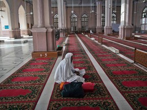 A man reads verses of the Qur'an on the second day of the holy month of Ramadan while sitting in the hall of Karachi's Memon Mosque on July 22, 2012. (REUTERS/Akhtar Soomro)