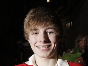 Brad McCrimmon's son Liam shows off the silver puck he was given in a ceremony honouring his late father before NHL hockey action between the Calgary Flames and Detroit Red Wings at the Scotiabank Saddledome. (LYLE ASPINALL/QMI AGENCY)