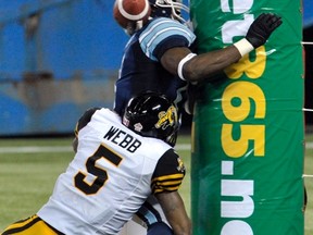Argos wide receiver Dontrelle Inman, with defensive back Dee Webb of the Tiger-Cats covering, slams into the goalpost after failing to hang on to a touchdown pass yesterday. (Mike Cassese/Reuters)