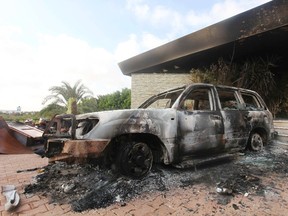 A burned car is parked at the U.S. consulate, which was attacked and set on fire by gunmen yesterday, in Benghazi September 12, 2012.  REUTERS/Esam Al-Fetori
