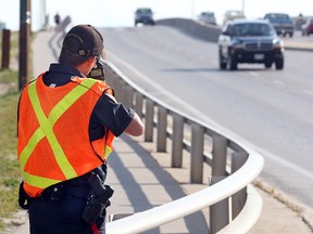 A Winnipeg Police officer checks for speeders on the Slaw Rebchuk Bridge. (BRIAN DONOGH/WINNIPEG SUN)