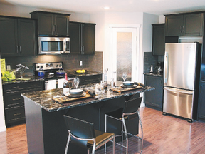 The first thing you’ll notice in the kitchen is the striking interstellar black and off-white granite countertops.