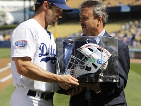 Los Angeles Dodgers General Manager Ned Colletti presents an encased catchers mask to Dodgers' catcher Brad Ausmus representing his career achievements before the MLB national league baseball game against the Arizona Diamondbacks in Los Angeles, October 3, 2010. (REUTERS/Danny Moloshok)