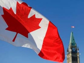 A Canadian flag waves in front of Parliament Hill in Ottawa. Chris Roussakis/QMI Agency