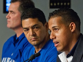 Yunel Escobar (right) is joined by manager John Farrell (left) and coach Luis Rivera at a news conference in New York on Tuesday in which the shortstop apologized for wearing an offensive message in his black eye. The Jays suspended him for three games. (Reuters)
