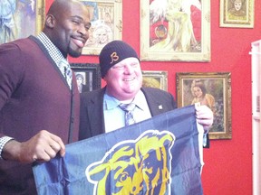 Mayor Rob Ford receives a Chicago Bears hat and flag from Chicago Bears defensive lineman Israel Idonije at the Chicago Cultural Centre Tuesday, September 18, 2012. Idonije is a Nigerian-Canadian who was signed out of the University of Manitoba. (DON PEAT/TORONTO SUN)