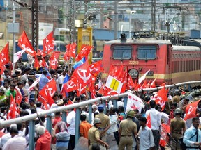 Activists of the Communist Party of India-Marxist (CPI-M) block a passenger train while protesting during a nationwide strike in the southern Indian city of Chennai Sept. 20, 2012.  REUTERS/Babu