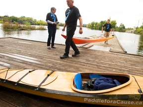 Father-and-son team Andy and Nick Fauset load a pair of kayaks onto a dock joined by director of Strategic Planning for Prostate Cancer Canada  on Saturday, Sept. 22, 2012 during a noon-hour reception at the Siver Bean Cafe� at Millennium Park in Peterborough to greet well-wishers and hand out literature on prostate cancer. The pair  raised almost $7,000 for prostate cancer research on their 250-kilometre kayak trip. The two set out Sept. 5 from Port Severn planning to take 18 days to paddle the Trent-Severn Waterway to the Silver Bean Caf�.
CLIFFORD SKARSTEDT/PETERBOROUGH EXAMINER/QMI AGENCY