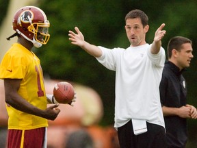 Washington Redskins quarterback Robert Griffin III (L), the second pick in last month's NFL draft, listens to offensive coordinator Kyle Shanahan (R) during a rookie minicamp at the team's training facility in Ashburn, Virginia May 6, 2012. REUTERS/Jonathan Ernst