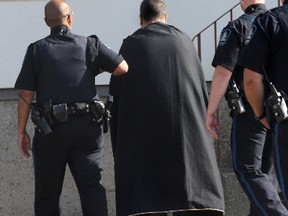 One of the parents of Baby M is lead into the backdoor of the Al-Rashid Mosque after funeral services in Edmonton Alberta on Saturday, September 22, 2012.(QMI Agency/PERRY MAH)