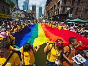Revelers hold a giant pride flag as the take part in the Gay Pride Parade in Toronto, July, 3, 2011. (Reuters/MARK BLINCH)