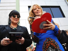 Ann (L) and Nancy Wilson of Rock band Heart sign autographs after unveiling their star on the Walk of Fame in Hollywood, California September 25, 2012. (Reuters/MARIO ANZUONI)