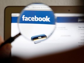 A Facebook logo on a computer screen is seen through a magnifying glass in Bern in this file photo illustration taken May 19, 2012. (REUTERS/Thomas Hodel/File)