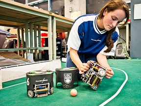 Mechanical engineering student Andrea Palmer toys with one of the UBC Thunderbots - autonomous soccer-playing robots - at a University of B.C. lab. (CARMINE MARINELLI/24 HOURS)