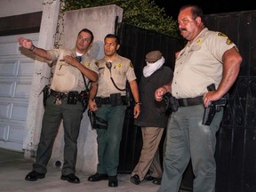 Basseley Nakoula (2nd R) is escorted out of his home by Los Angeles County Sheriff’s officers in Cerritos, California in this file photo taken September 15, 2012.   REUTERS/Bret Hartman/Files