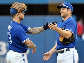 Brett Lawrie and Adam Lind celebrate the Jays' 3-2 win over the Yankees on Sunday. (Reuters)