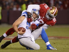 Alson Smith #99 of the San Francisco 49ers sacks quarterback Matthew Stafford #9 of the Detroit Lions during the fourth quarter of an NFL football game at Candlestick Park on September 16, 2012 in San Francisco, California. The 49ers won the game 27-19. (Thearon W. Henderson/AFP)