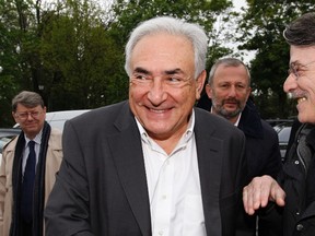 Former IMF head Dominique Strauss-Kahn (C) and Francois Pupponi (2ndR), Deputy Mayor of Sarcelles arrive at a polling station in the second round of the 2012 French presidential elections in Sarcelles in this May 6, 2012, file photo.  REUTERS/Gonzalo Fuentes/Files