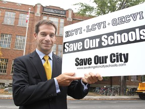 Jason Trueman, a member of Save Our Schools, stands in front of KCVI with one of the group's signs.
Michael Lea The Whig-Standard