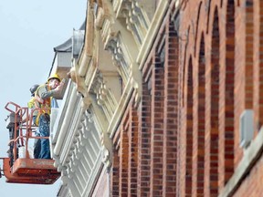 FALL TOUCHUP
SCOTT WISHART The Beacon Herald
Working high above Ontario St., Mat Casler, front, and Andrew Klomp, both of McDonnell Carpentry, add a fresh coat of paint to soffits, fascia and columns on a section of historic building in the city core Tuesday.