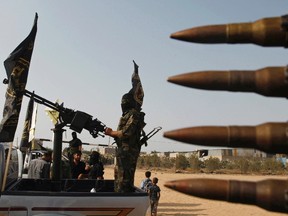 An Islamic Jihad militant rides on the back of a pick-up truck during a parade to mark the 25th anniversary of the movement's foundation in Rafah in the southern Gaza Strip October 2, 2012. REUTERS/Ahmed Zakot