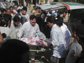 Hospital staff assist Malala Yousufzai, a 14-year-old schoolgirl who was wounded in a gun attack, at Saidu Sharif Teaching Hospital in the Swat Valley region in northwest Pakistan Oct. 9, 2012. REUTERS/Hazart Ali Bacha